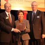Dr. David Rankin, president of SAU, accepts the Commitment Award from Maria Haley, director of the Arkansas Economic Development Commission, and  John Womack, CEO of Arvest Bank.