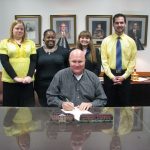 FBLA week Magnolia Mayor Parnell Vann signs a proclamation for National FBLA-PBL Week as SAU PBL officers Kristi Canada of Camden, Brittany Holleman of Prescott, Valerie Smith of Junction City, and Tommy Clark of Magnet Cove look on.